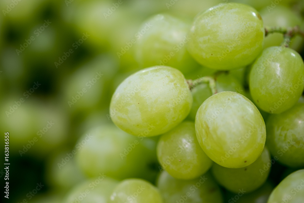 Macro shot of new harvest green-yellow grapes for sale at local farmers market Macro shot of new harvest green-yellow grapes for sale at local farmers market