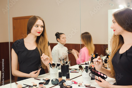 A professional make-up artist prepares to work in front of a mirror