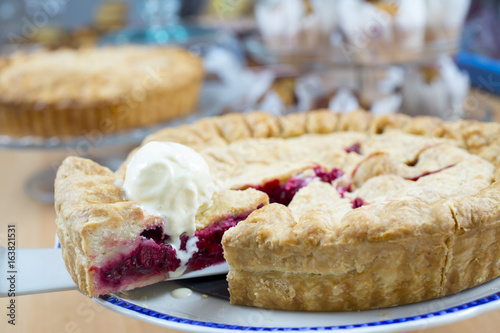 Homemade traditional sweet raspberry tart pie with ice cream on wooden table background. photo