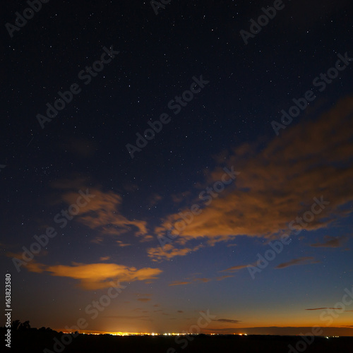 Clouds at night against the background of bright stars in the sky after sunset.