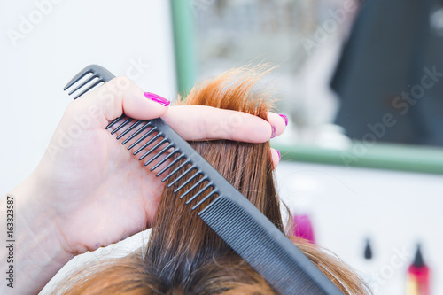 hairdresser cutting hair to customer