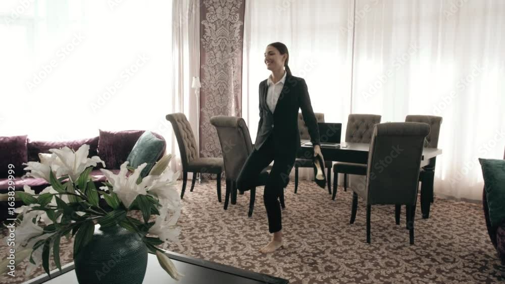 Dancing Happy successful business woman in modern loft workplace. Businesswoman dance in big hotel room, jumping and throwing shoes