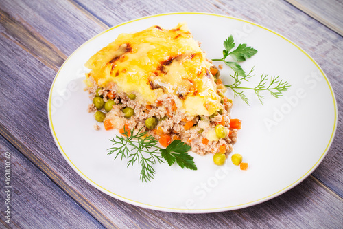 Traditional shepherd pie. Meat, potato, cheese, carrot, onion and green peas casserole