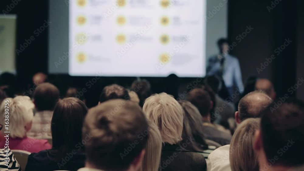 Speakers on the stage with Rear view of Audience in the conference hall or seminar meeting, business and education concept