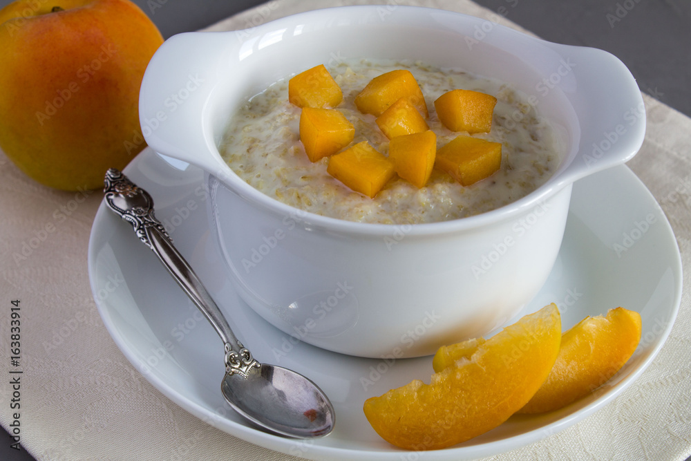 Oatmeal with milk and apricot in the white plate Oatmeal with milk and apricot in the white plate