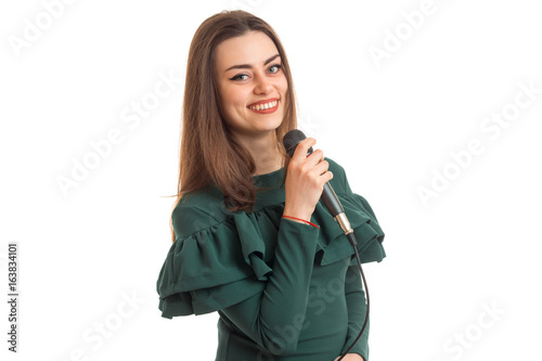 cheerful young woman in green dress singing song with karaoke