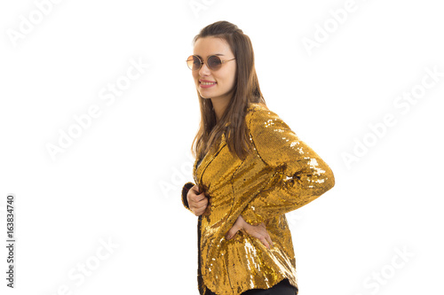 happy stylish woman in golden jacket and sunglasses