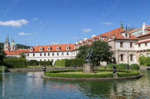 Pool, statue and building at the Wallenstein (Waldstein) Garden (Valdstejnska Zahrada). It's a public Baroque garden at Lesser Town in Prague, Czech Republic. St. Nicholas Church is in the background.