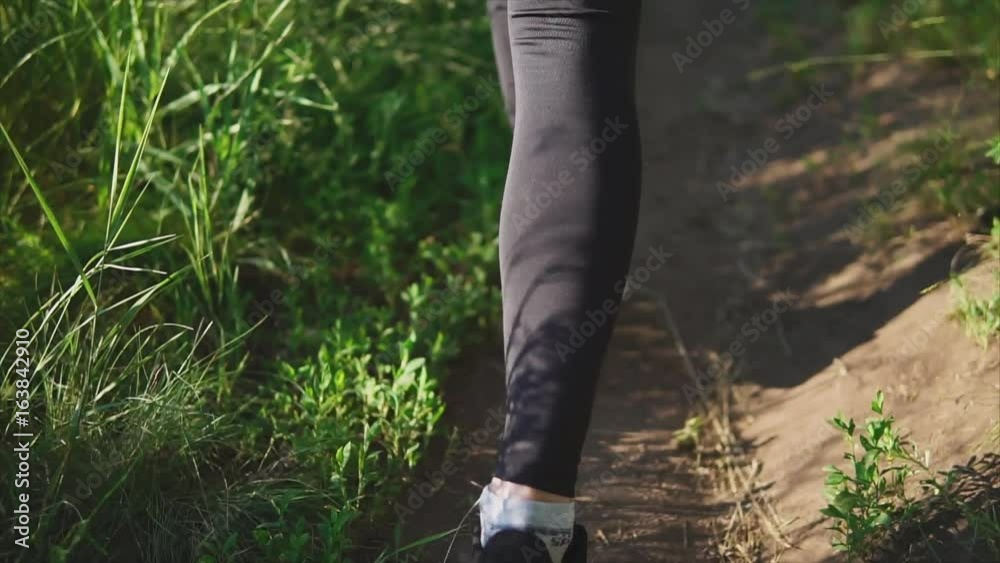 Close-up shot of female legs climbing up the slope shod in sneakers. Close-up shot of female legs climbing up the slope shod in sneakers.