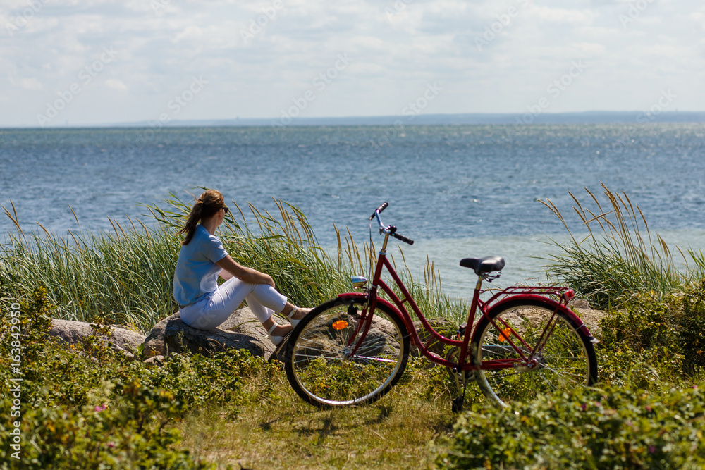 Fototapeta premium Woman with bike at seaside