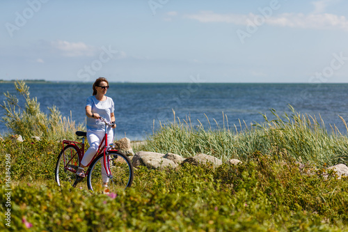 Woman with bike at seaside