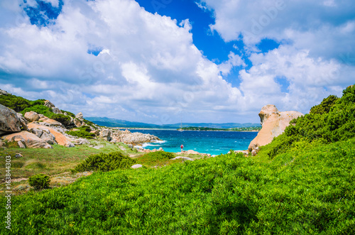 Costline with cloudscape and granite rocks and azure water near Porto Pollo, Sardinia, Italy photo