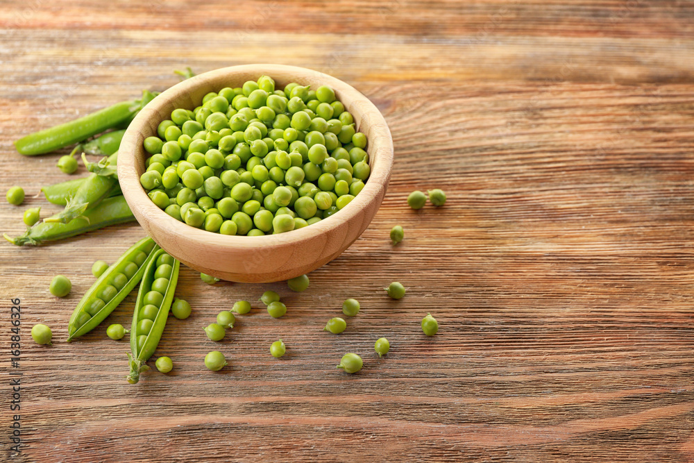 Bowl with fresh green peas on wooden background Bowl with fresh green peas on wooden background
