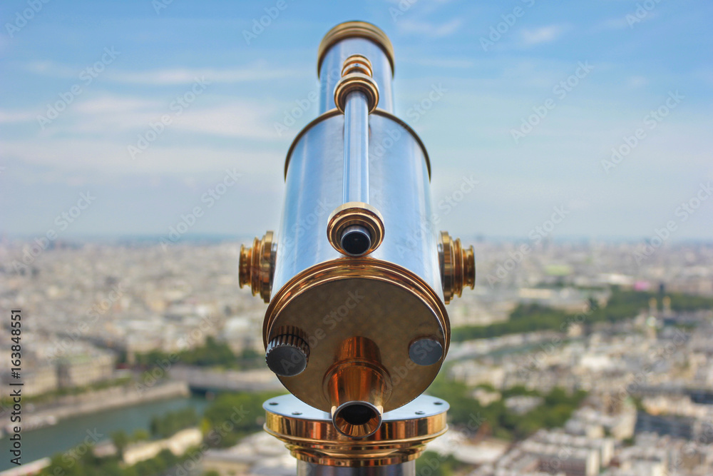 Viewer telescope at top of Eiffel tower overlooking Paris