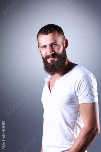 Portrait of handsome man standing, isolated on grey background © lenets_tan