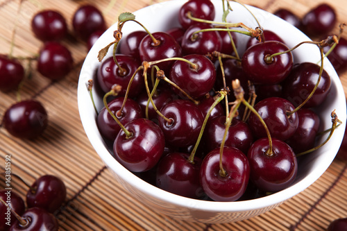 Ripe sweet cherry in a bowl on a napkin