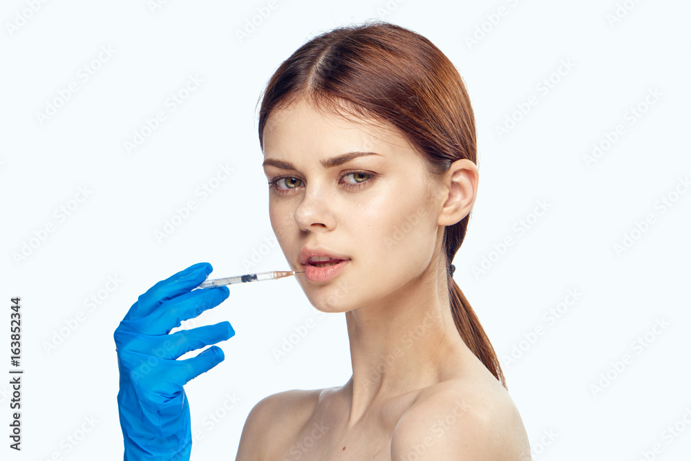 Young beautiful woman on white isolated background holds a syringe, medicine, nurse Young beautiful woman on white isolated background holds a syringe, medicine, nurse