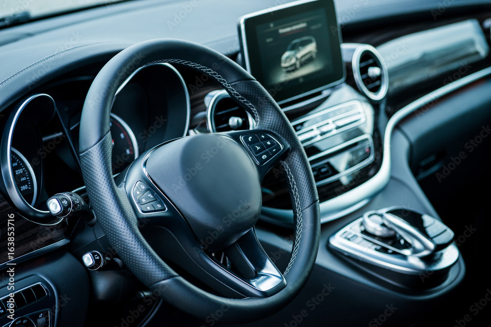 Auto. Luxury car steering wheel and dashboard