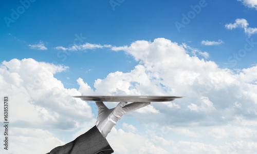Waiter holding empty silver platter ready for product or item placement