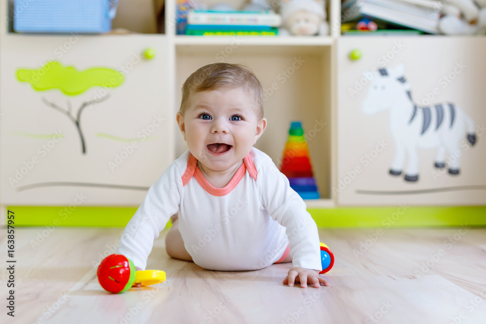 Cute baby girl playing with colorful rattle toys Cute baby girl playing with colorful rattle toys