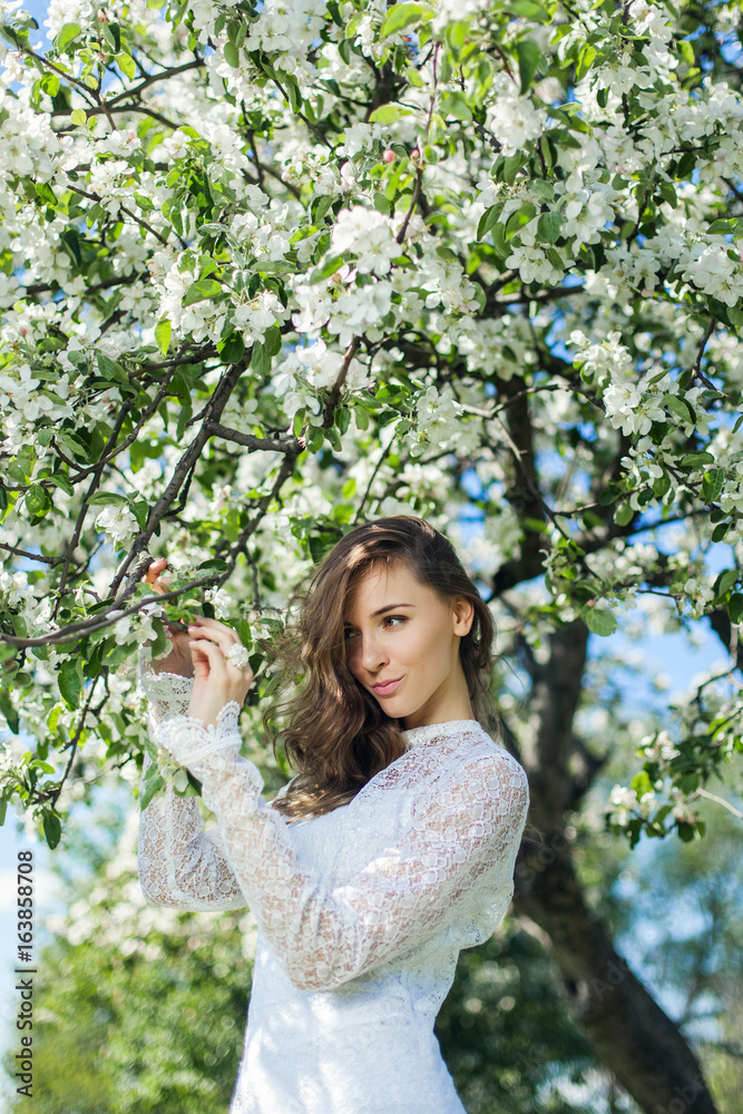 Beautiful brunette posing in blossoming apple-trees Beautiful brunette posing in blossoming apple-trees