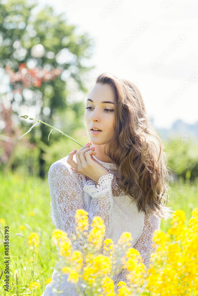 Naklejka premium Beautiful brunette posing in blossoming apple-trees