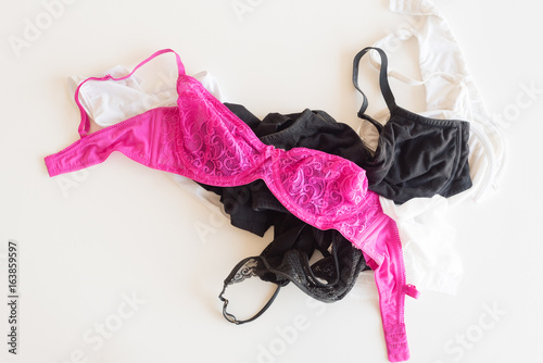 High angle view of women's pink, black and white bras in a messy pile