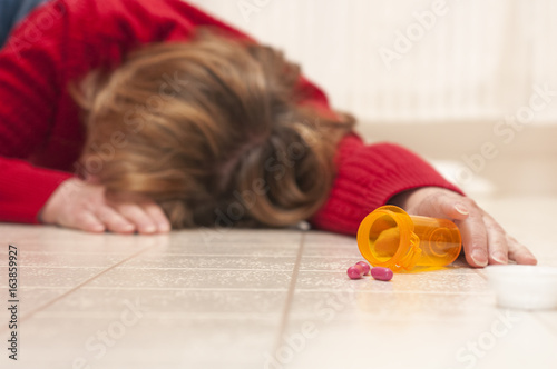 Tableau sur toile Unconscious woman with drug bottle