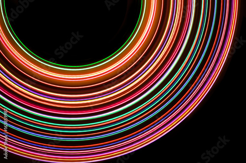 Neon color glowing lights texture with black empty copy space inside.