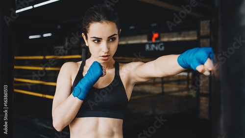 Beautiful and fit female fighter getting prepared for the fight or training