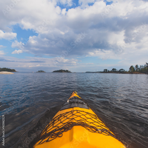 A process of kayaking in the lake skerries, with colorful canoe kayak boat paddling, process of canoeing, vibrant summer picture © tsuguliev