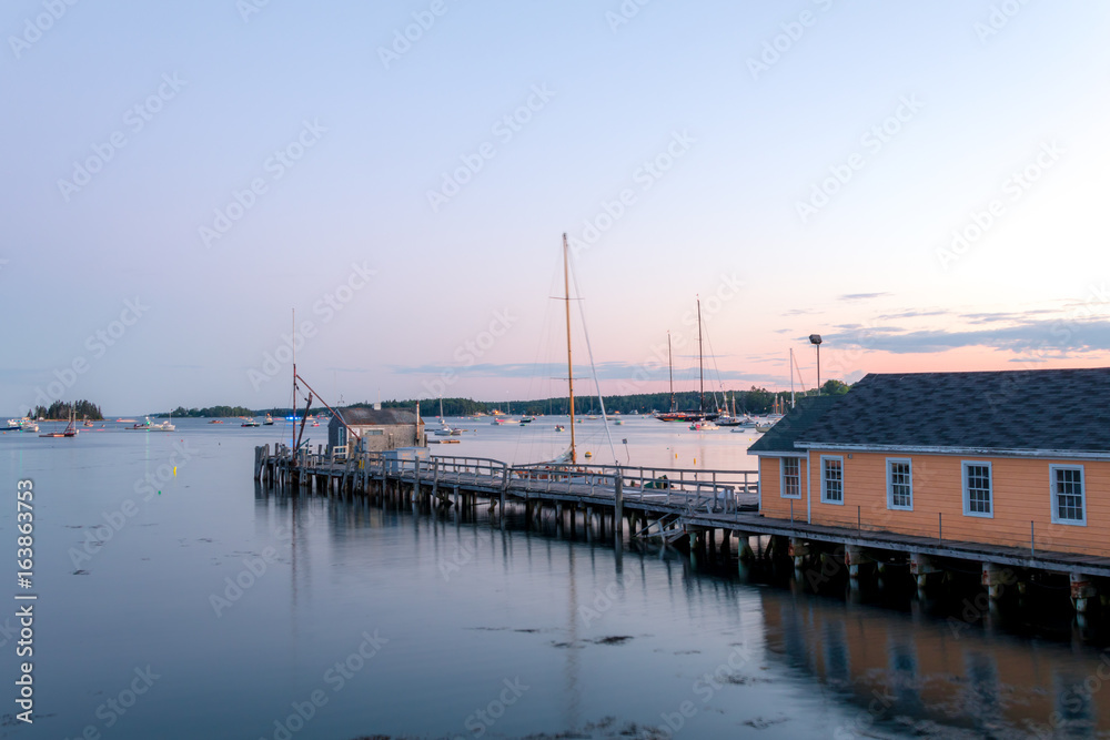 Boathouse and dock in the calm and beautiful Boothbay Harbor at dusk