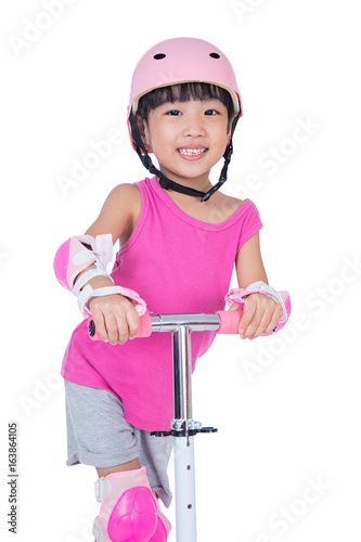 Asian little Chinese girl playing with scooter