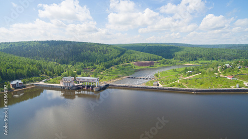 Panorama of spillway on old hydroelectric power station in sunny day aerial view