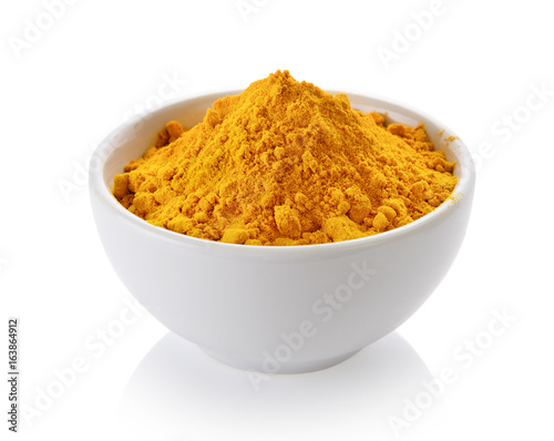 Turmeric powder in white cup on white background © sommai