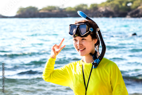An oriental girl with snorkeling gears is having fun at beach, the Island of Hawaii
