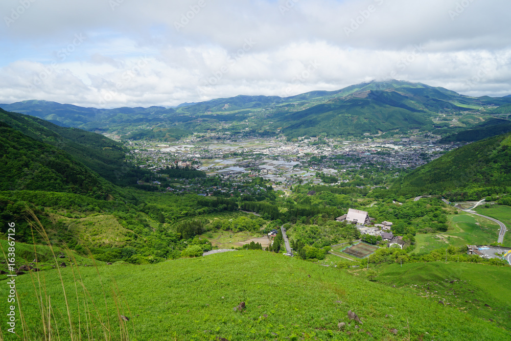 Lush greenery mountain landscape panorama and town view with cloudy sky