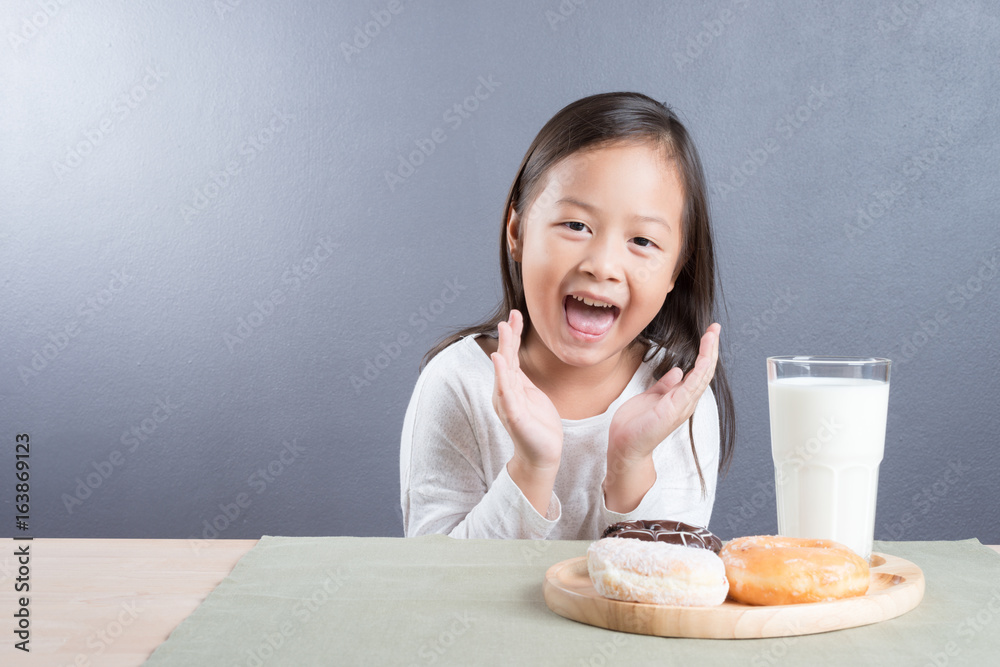 Asian kid girl happy to eat doughnut and milk Asian kid girl happy to eat doughnut and milk