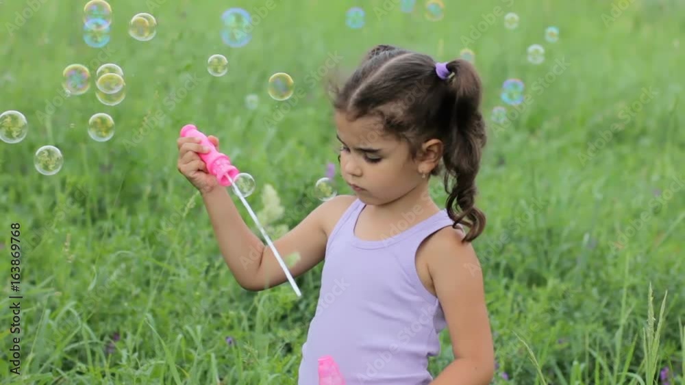 child puff soap bubbles. girl inflate soap bubbles. little curly girl blowing soap bubbles child puff soap bubbles. girl inflate soap bubbles. little curly girl blowing soap bubbles
