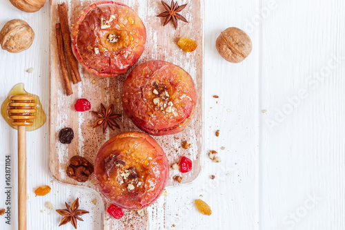 Red baked apples with cinnamon, walnuts and honey. Autumn or winter dessert.