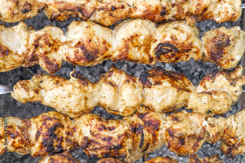Shish kebab close-up. Slices of meat in marinade preparing on fire