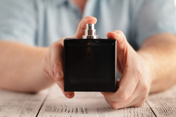Fototapete Schönheitssalon Männerhand hält Parfumflakon  © Andrey Cherkasov