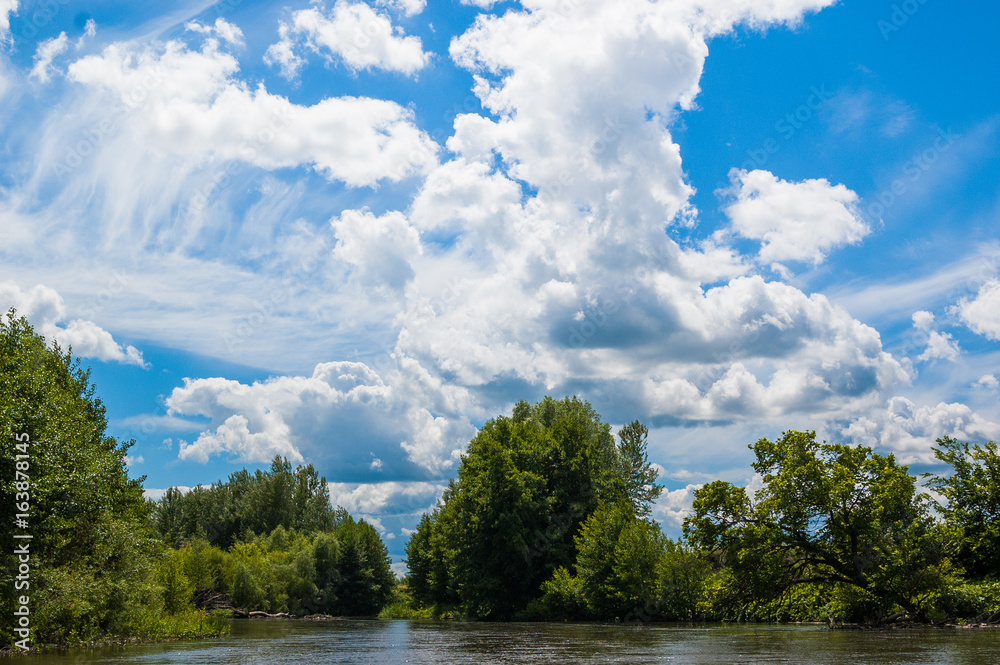 Beautiful nature of Russia. The Tereshka River in summer. River, trees by the river and a beautiful cloudy sky