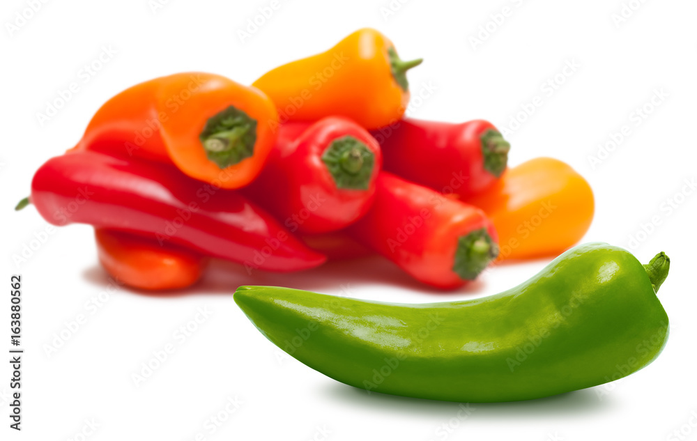 Green pepper and heap of red and orange over white