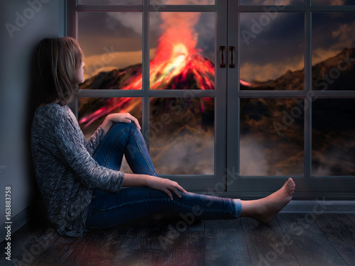 Fotografie, Obraz The girl looks out the window at a natural disaster - the eruption of the volcan