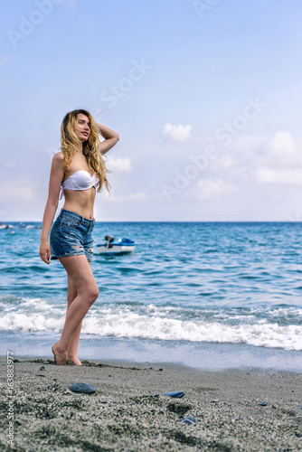 Girl at the beach in Monterosso al Mare Italian riviera. Sea and mountain view. Cinqueterre Liguria