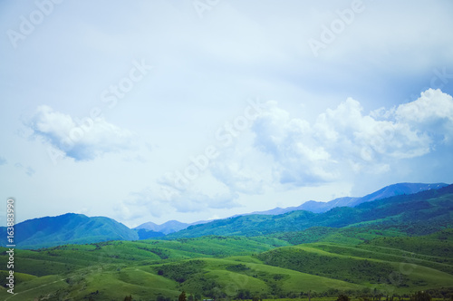 Green hills, mountains valley and blue sky. Beautiful landscape at sunny day.