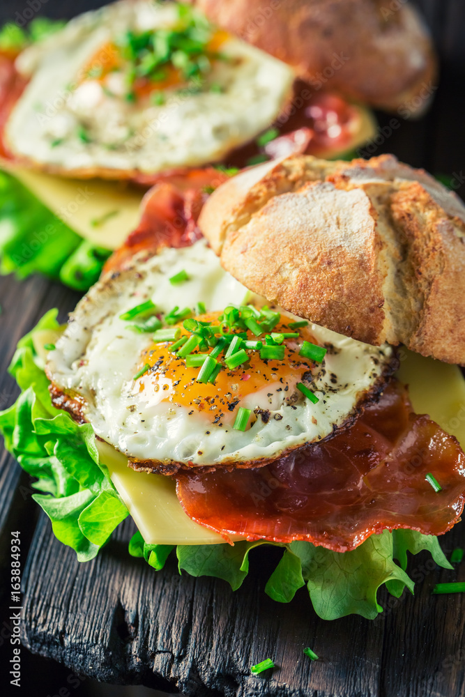 Closeup of burger with lettuce, bacon and eggs Closeup of burger with lettuce, bacon and eggs