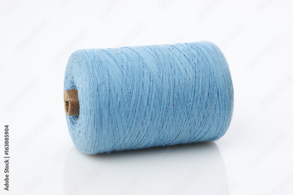 bobbin with blue thread on a white background bobbin with blue thread on a white background