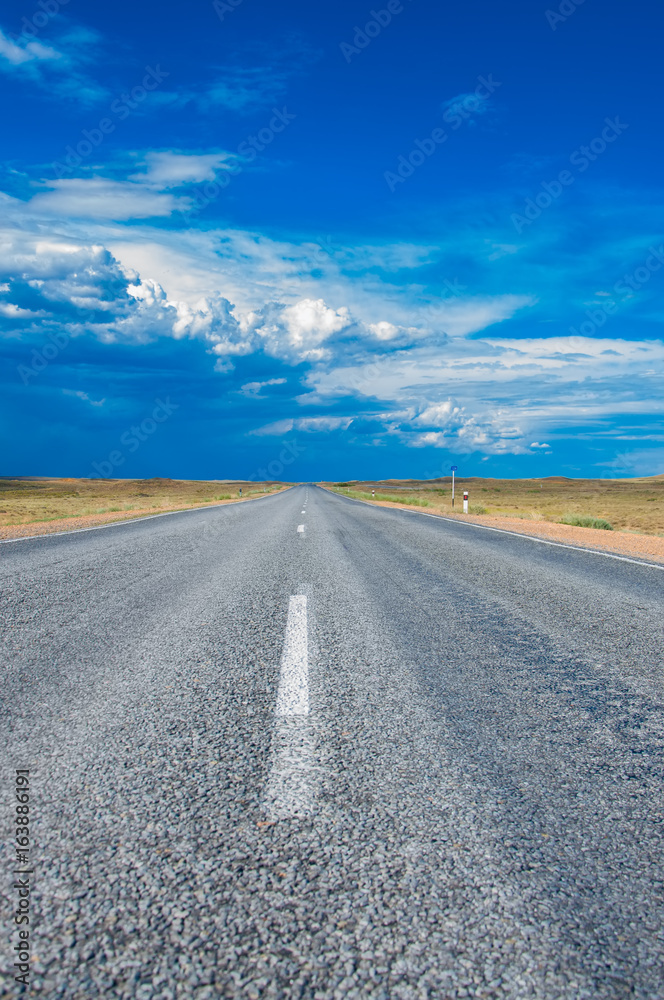 Picturesque landscape and blue sky with clouds above asphalt straight road Picturesque landscape and blue sky with clouds above asphalt straight road